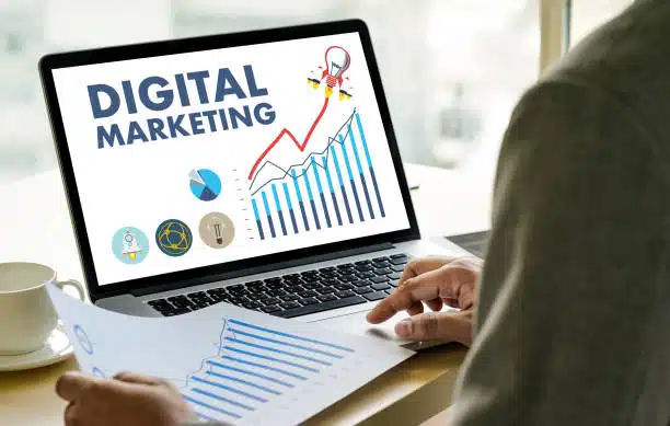 Business team working on a digital marketing project with financial reports on a laptop